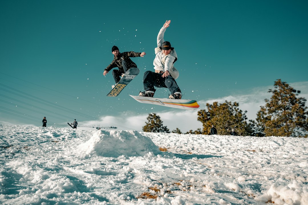 beginner snowboarding tips cover image: a new rider practicing on a gentle green run with clear blue skies